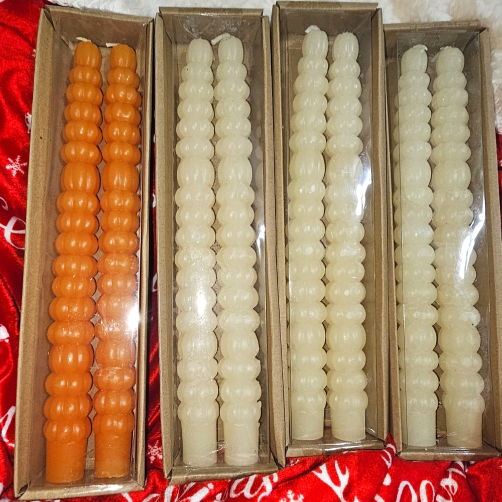 4 taper candles. 1 orange, 3 ivory
